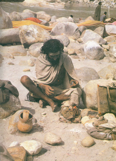 An ascetic takes stock of his meagre possessions while seated on the bank of a sandy glacial river. Unplanned exploitation by industry has taken away the vital timber resources which common hill folk depend on for their survival. An ascetic takes stock of his meagre possessions while seated on the bank of a sandy glacial river. Unplanned exploitation by industry has taken away the vital timber resources which common hill folk depend on for their survival.