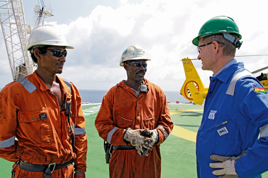 Solheim interacts with operators atop the Eirik Raude drilling platform, one of the largest of its kind, in Ghana.